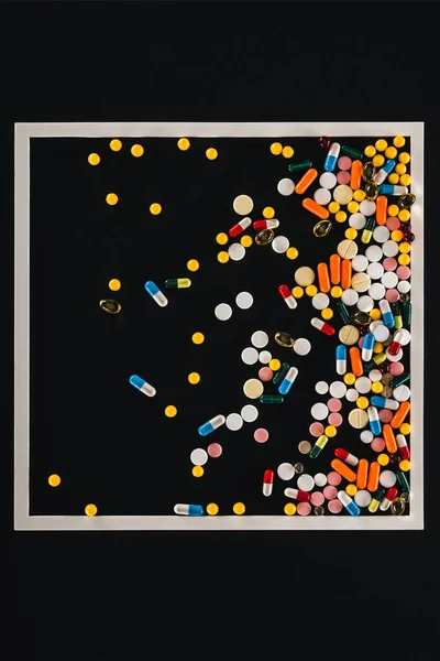 Top view of frame with pile colorful various pills isolated on black — Stock Photo