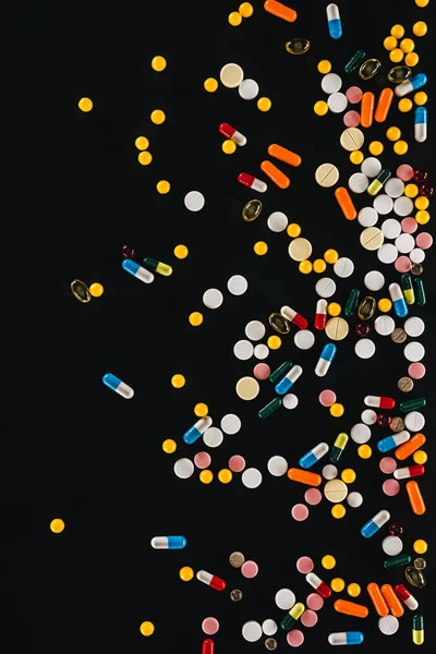 Top view of pile colorful various pills isolated on black — Stock Photo
