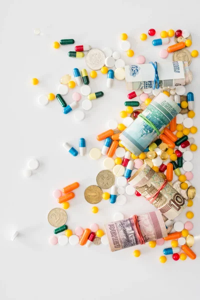 Top view of colorful various pills and russian rolled banknotes on surface — Stock Photo