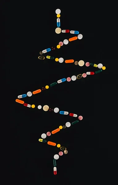 Flat lay com arranjado colorido várias pílulas isoladas em preto — Fotografia de Stock