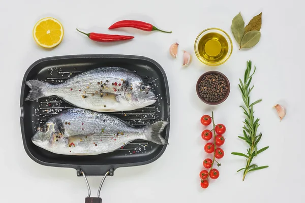 Flat lay with various ingredients, uncooked fish decorated by lemon and cherry tomatoes in baking tray — Stock Photo