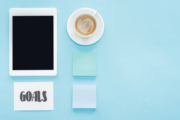 Organized flat lay of digital tablet with blank screen, sticky notes and 'goals' lettering on card with blue background — Stock Photo