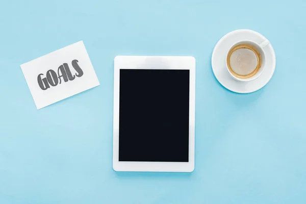 Vista superior de la tableta digital con pantalla en blanco, letras de 'objetivos' en la tarjeta y el café con fondo azul - foto de stock