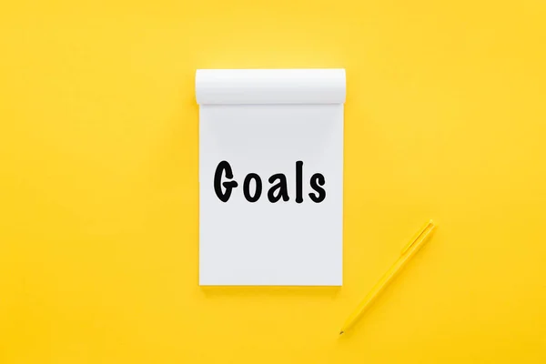 Top view of notebook with 'goals' word on yellow, goal setting concept — Stock Photo