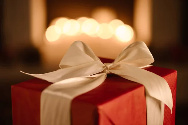 Red present with white bow on blurred background — Stock Photo