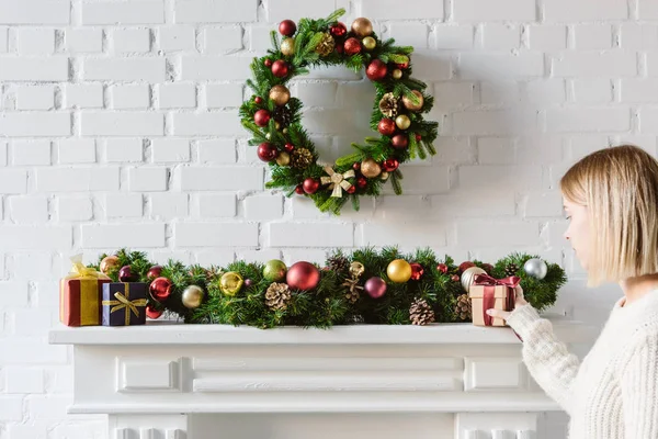 Christmas wreath and decorations over fireplace mantel with white brick wall — Stock Photo