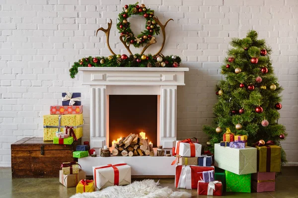 Праздничная гостиная с уютным камином, елка и подарки — стоковое фото