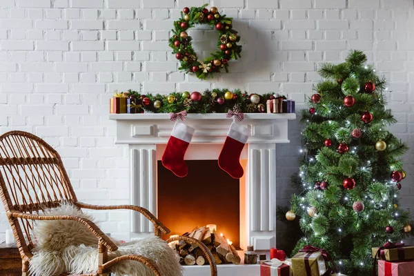 Sala de estar com lareira, cadeira de balanço e árvore de natal decorada — Fotografia de Stock