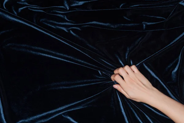 Cropped view of female hand tightly holding dark velvet cloth — Stock Photo