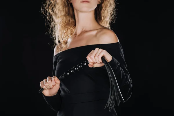 Abgeschnittene Ansicht einer Frau mit lederner Peitsche isoliert auf schwarz — Stockfoto