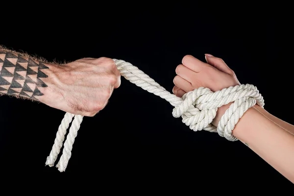 Vue recadrée de la corde dominante sur les mains soumises isolées sur noir — Photo de stock