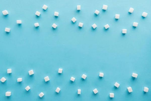 Вид сверху на кубики белого сахара с копировальным местом на синем фоне — стоковое фото