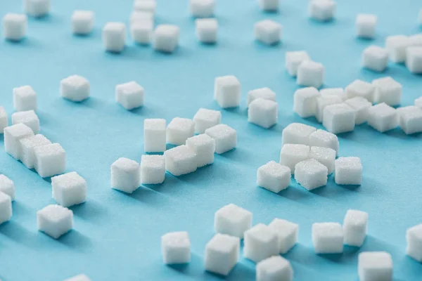 White sugar cubes on blue background — Stock Photo