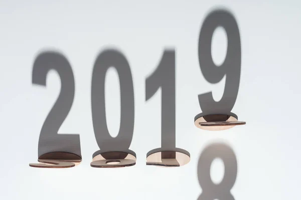 Ansicht von Holzzahlen mit Schatten auf weißem Hintergrund, die den Wandel von 2018 auf 2019 symbolisieren — Stockfoto