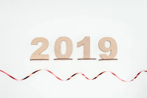 Top view of 2019 date made of wooden numbers with curly ribbon isolated on white — Stock Photo