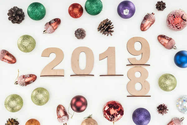 Ansicht von Holzzahlen mit Datum, das den Wandel von 2018 auf 2019 symbolisiert, mit Weihnachtsdekoration isoliert auf weiß — Stockfoto