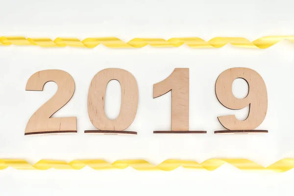 Top view of 2019 date made of wooden numbers with yellow ribbons isolated on white — Stock Photo