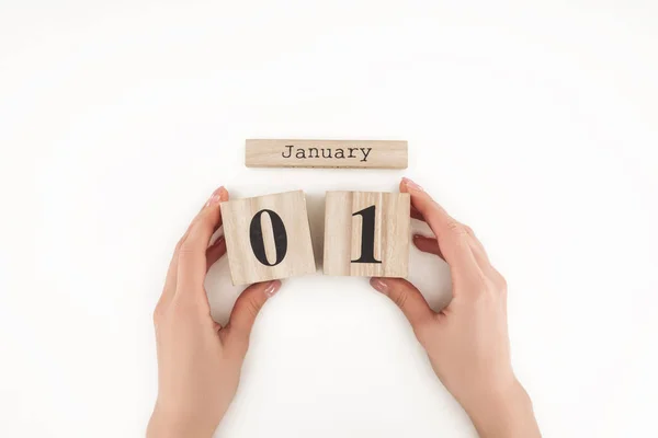 Cropped view of woman holding wooden cubes with january 1st date isolated on white — Stock Photo