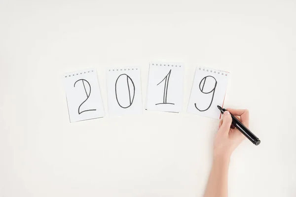 Vista parcial de la mujer escribiendo 2019 fecha con marcador aislado en blanco - foto de stock