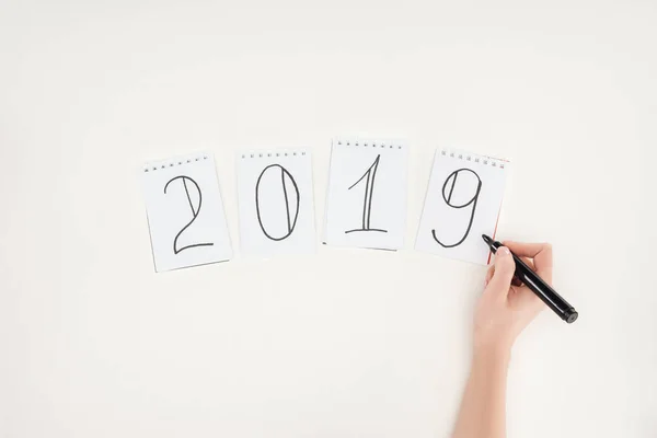 Teilansicht einer Frau, die das Datum 2019 mit Markierung auf Weiß schreibt — Stockfoto