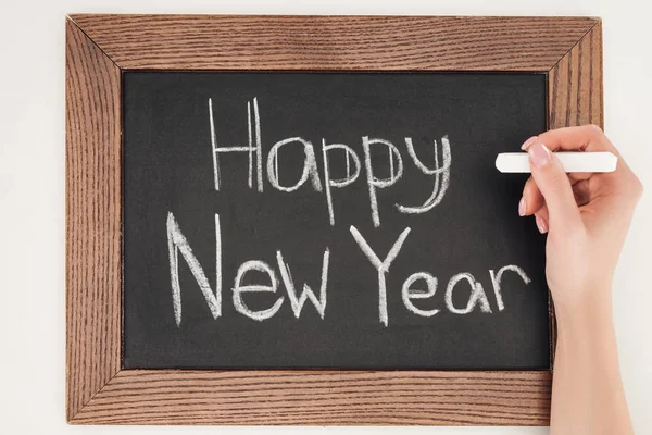 Cropped view of woman writing 'happy new year' text on chalk board with white background — Stock Photo