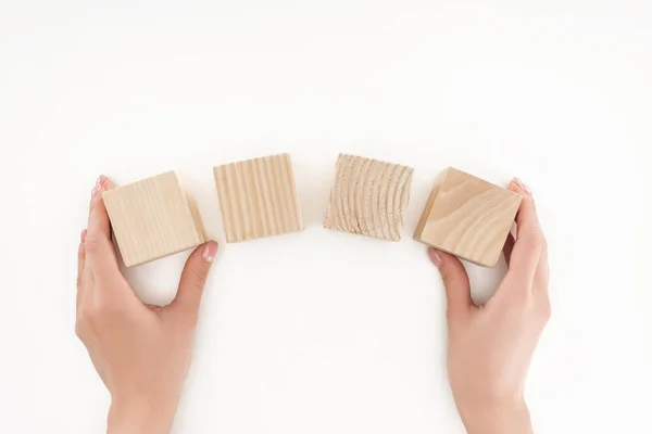 Vista cortada da mulher segurando quatro blocos de madeira isolados em branco — Fotografia de Stock