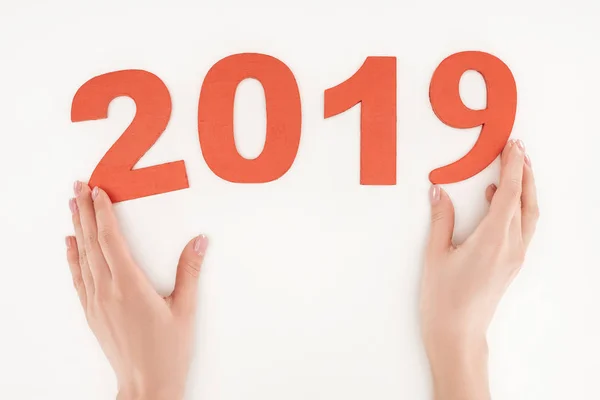 Vue recadrée de la femme ajustant la date 2019 faite de nombres rouges isolés sur blanc — Photo de stock