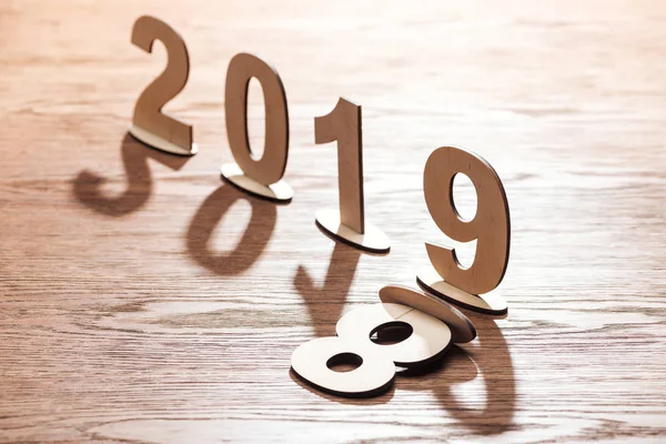 Vue du dessus des numéros en bois avec la date symbolisant le changement de 2018 à 2019 sur fond blanc — Photo de stock