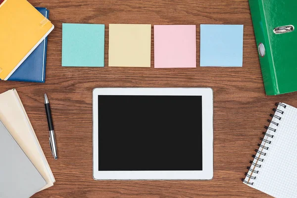 Vue de dessus de quatre notes collantes et tablette numérique avec écran blanc sur bureau en bois — Photo de stock