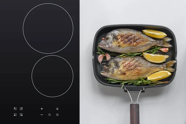 Вид на вкусную жареную рыбу Дорадо с розмарином, лимоном и чесноком — стоковое фото
