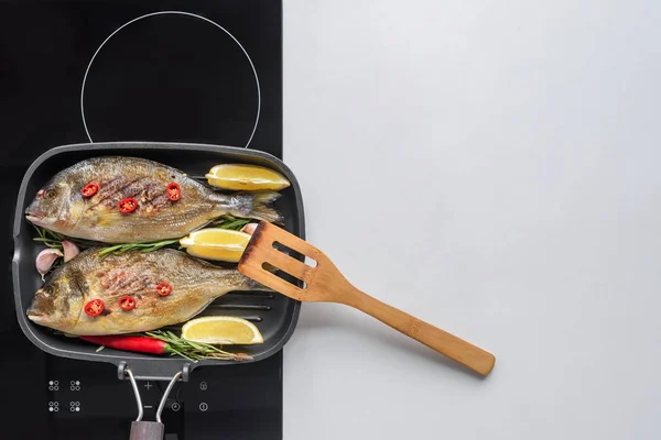 Top view of delicious fried fish with lemon and rosemary on grill — Stock Photo