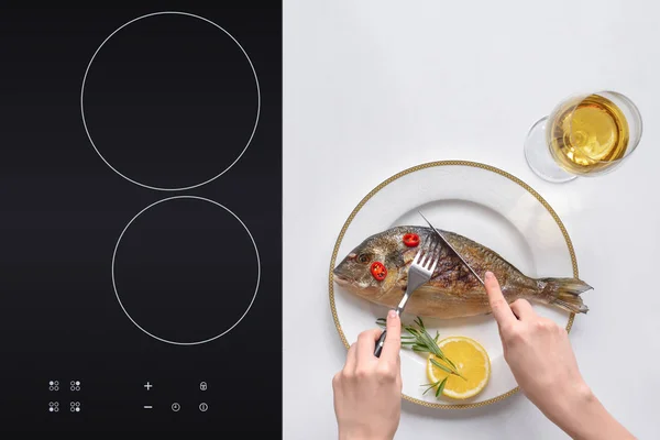 Partial top view of person eating gourmet fried fish with cherry tomatoes — Stock Photo