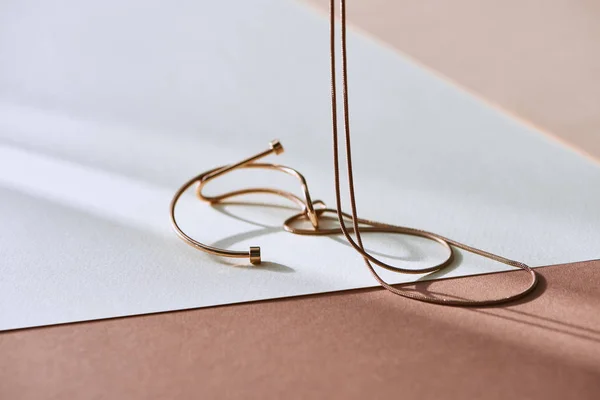 Primer plano de hermoso collar de lujo en la superficie blanca y beige con luz solar - foto de stock