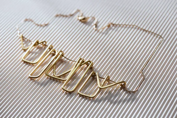 Close up of beautiful luxury necklace on striped white surface with sunlight — Stock Photo