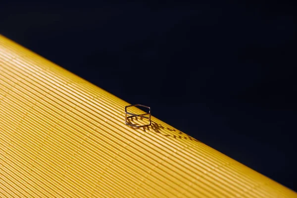 Anel de luxo bonito na superfície listrada amarela e preta — Fotografia de Stock