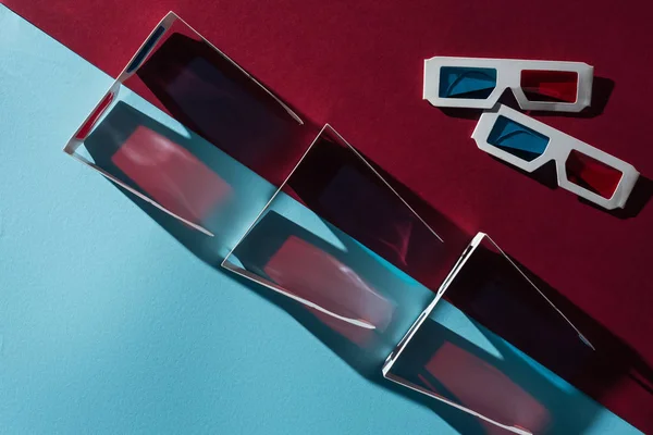 Vue du dessus des lunettes 3d avec ombres sur fond bleu et bordo — Photo de stock