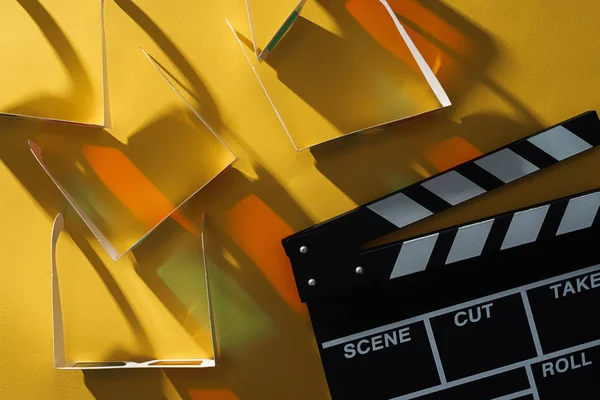 Top view of 3d glasses with shadows and clapperboard on yellow background — Stock Photo