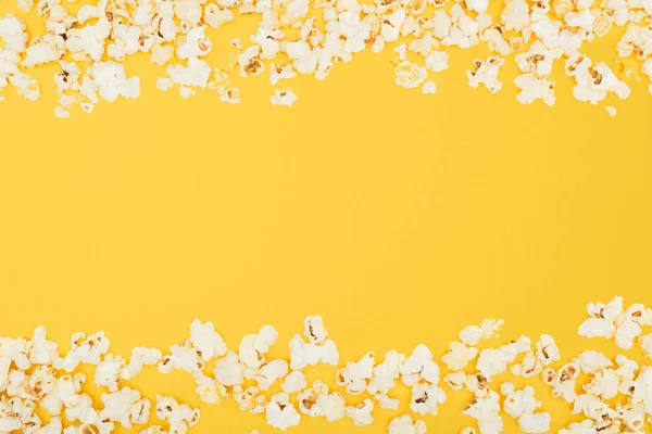 Горизонтальная рамка из свежего хрустящего попкорна, изолированного на желтом — стоковое фото