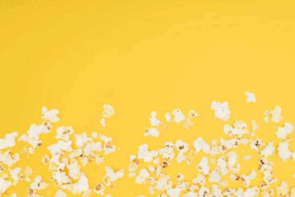 Bottom border of fresh tasty popcorn isolated on yellow — Stock Photo