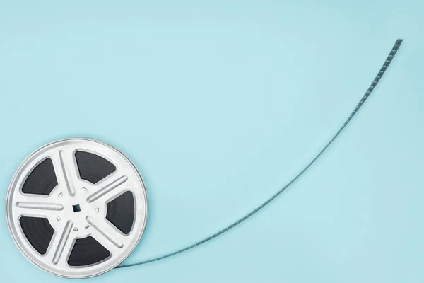 Movie reel with cinema tape isolated on blue — Stock Photo