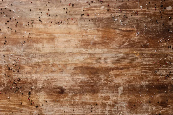 Vista dall'alto del tavolo in legno vintage con grani di pepe sparsi — Foto stock