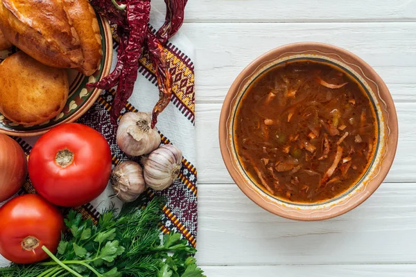 Vista superior de saborosa sopa tradicional de carne mista com mini tortas e ingredientes em fundo de madeira branca — Fotografia de Stock