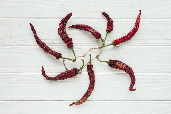 Bundle of red chilli peppers on white wooden background — Stock Photo