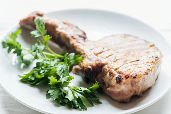 Close up of rib eye meat steak on plate with parsley — Stock Photo