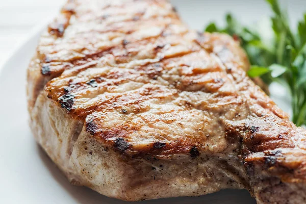 Close up of rib eye meat steak on plate with parsley — Stock Photo