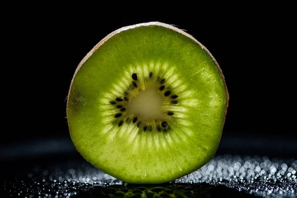 Rebanada de kiwi fresco sobre fondo negro - foto de stock