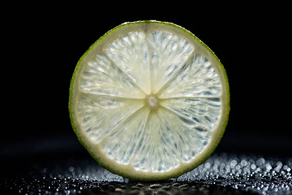 Slice of fresh lime on black background — Stock Photo