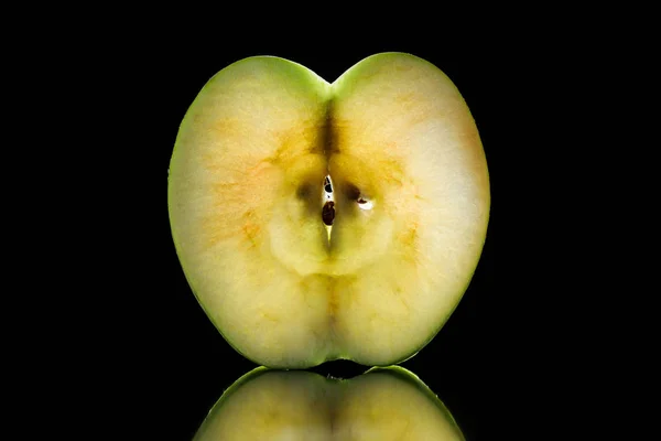 La mitad de la manzana cruda madura aislada en negro - foto de stock