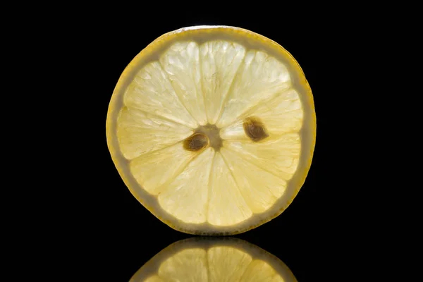 Slice of fresh ripe lemon isolated on black — Stock Photo