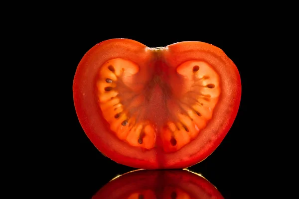 Slice of fresh ripe tomato isolated on black — Stock Photo